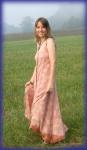 photo of Julie Rust wearing a long, sleeveless summer dress and standing in a field