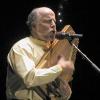 photo of John McCutcheaon playing autoharp in concert.